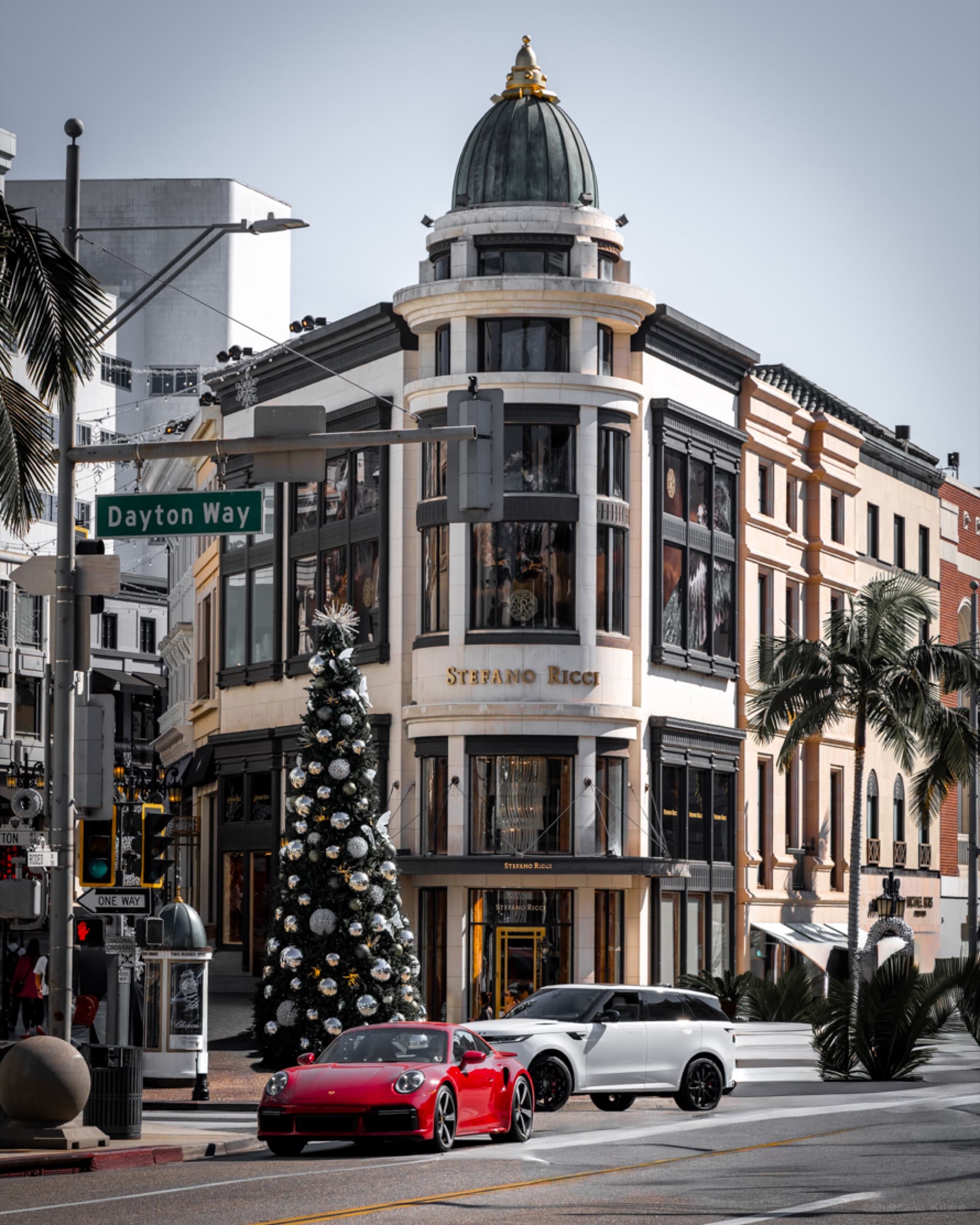 Brand and architecture photography — a domed corner building on Rodeo Drive, Beverly Hills, with a passing sports car.