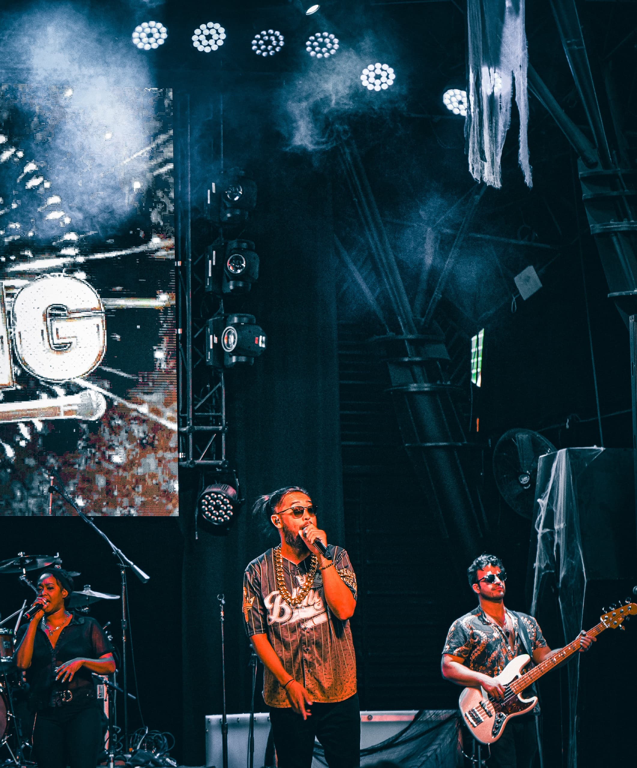 Event and film photography — a vocalist and band performing under stage lights at a live concert.